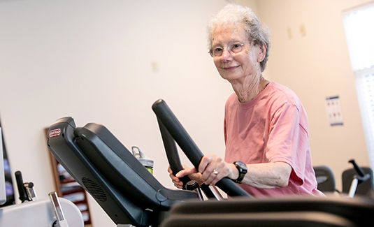 Female resident on exercise machine in the fitness center
