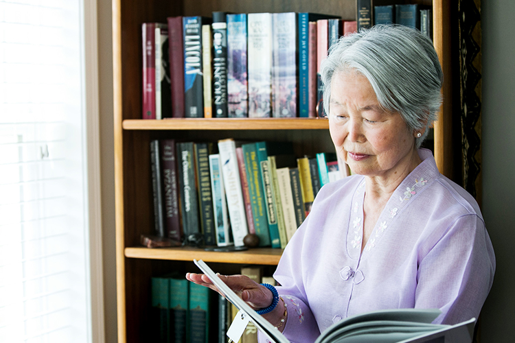 Asian-American resident reading a book at the regional library