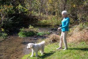 woman with dog near creek