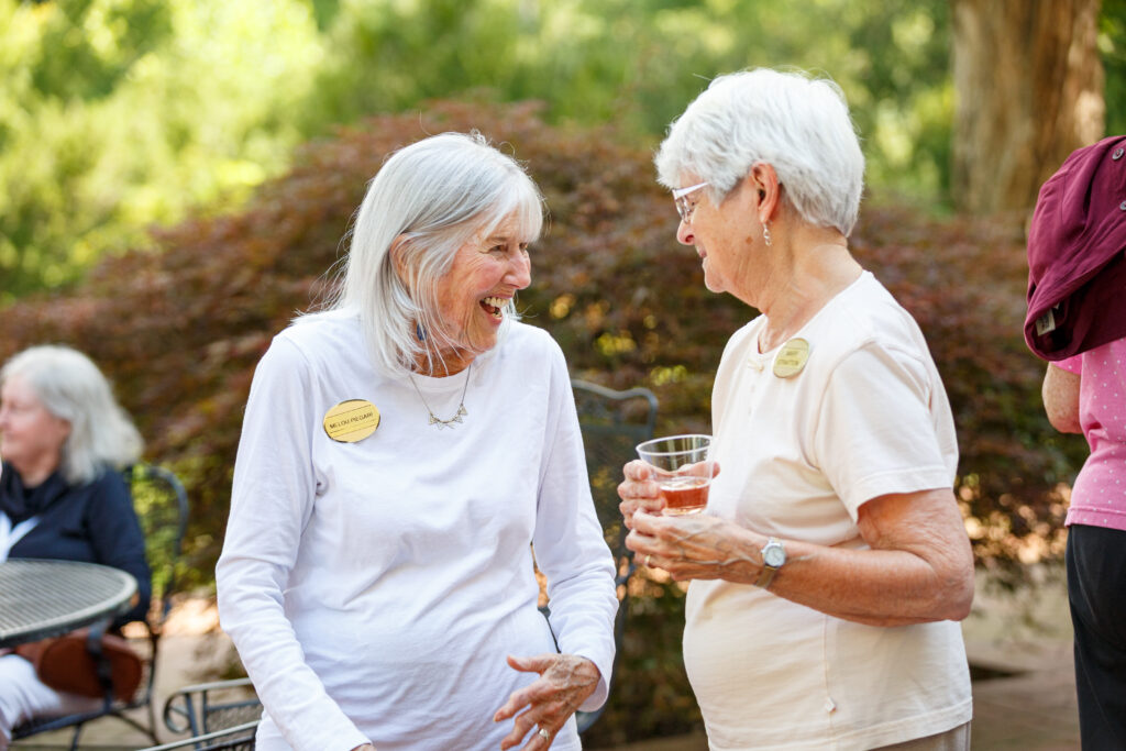 Two residents laughing together at a Kendal event. 